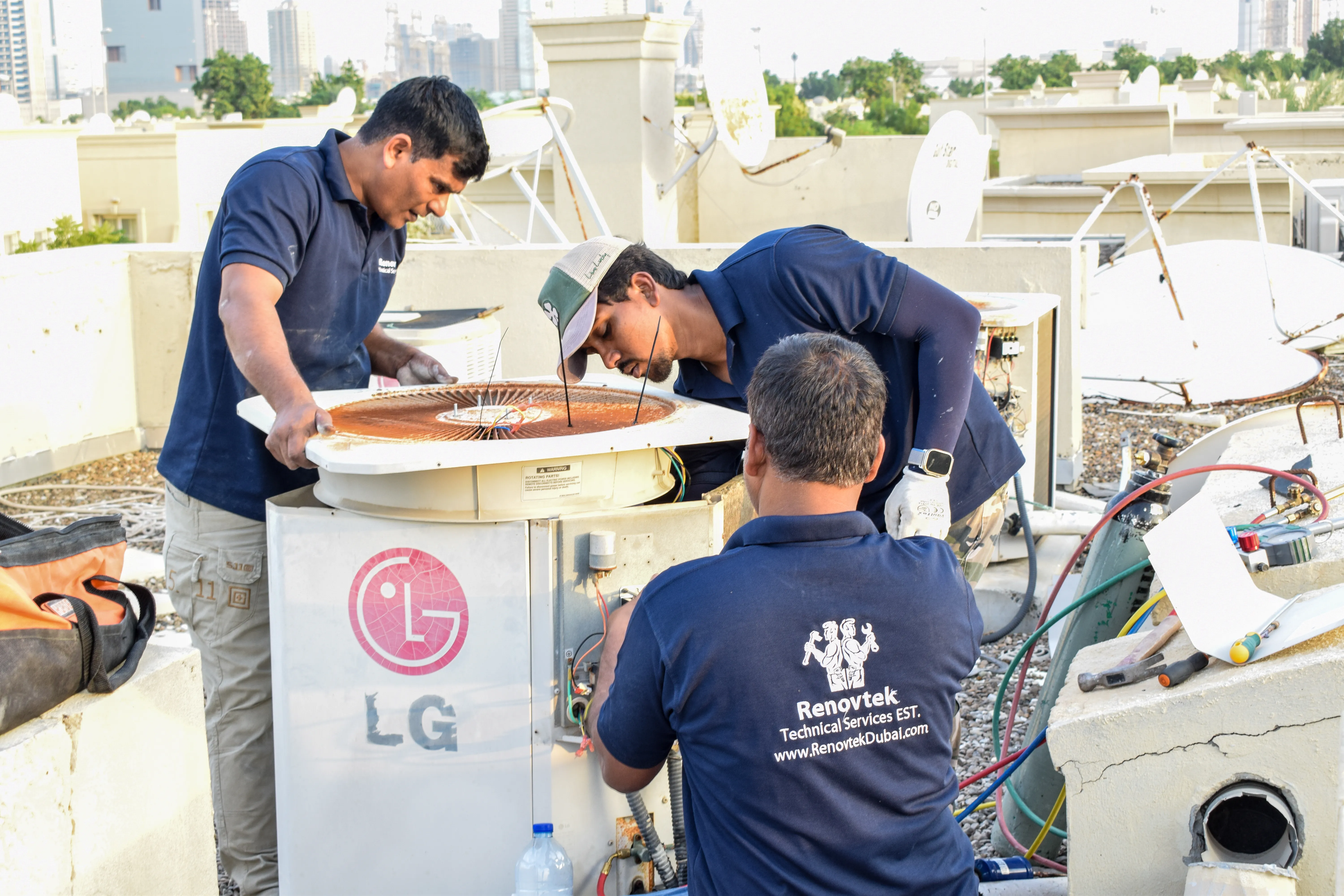 "Men working on an AC unit on the roof"