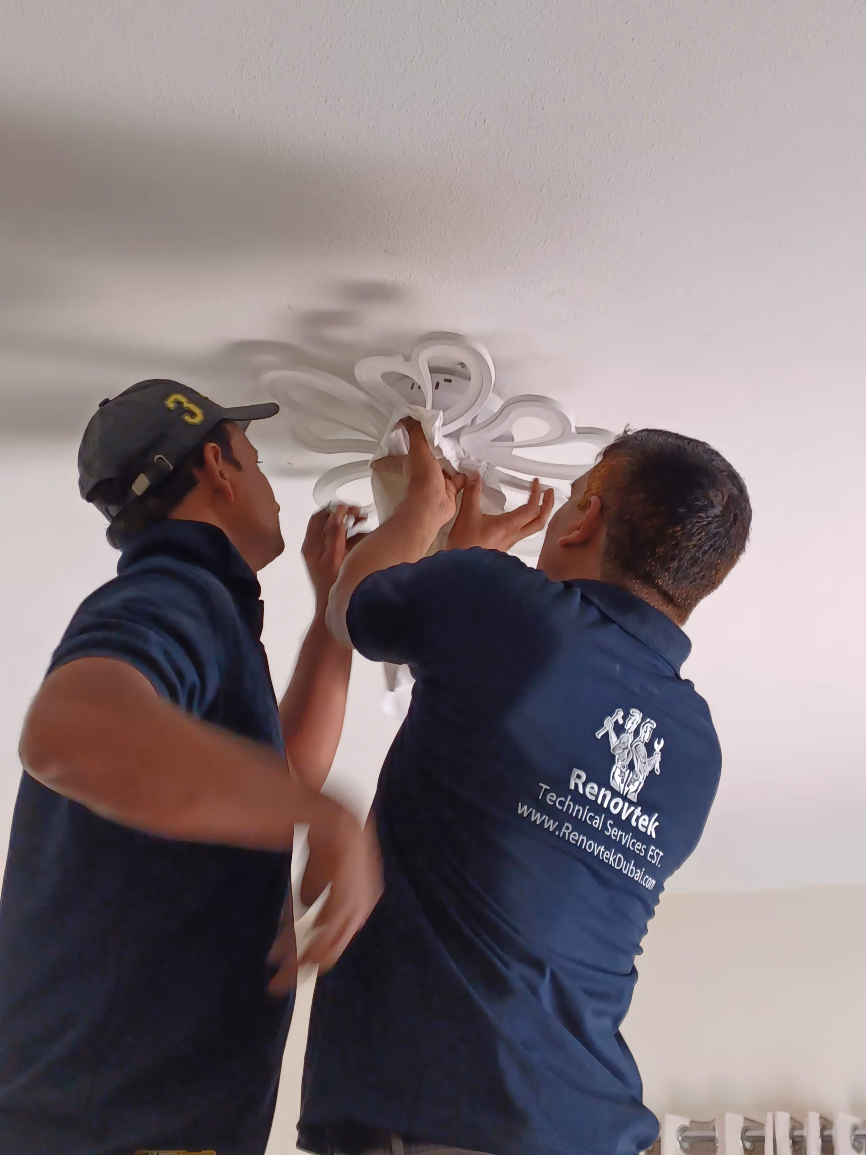 two technicians fixing a light in bedroom