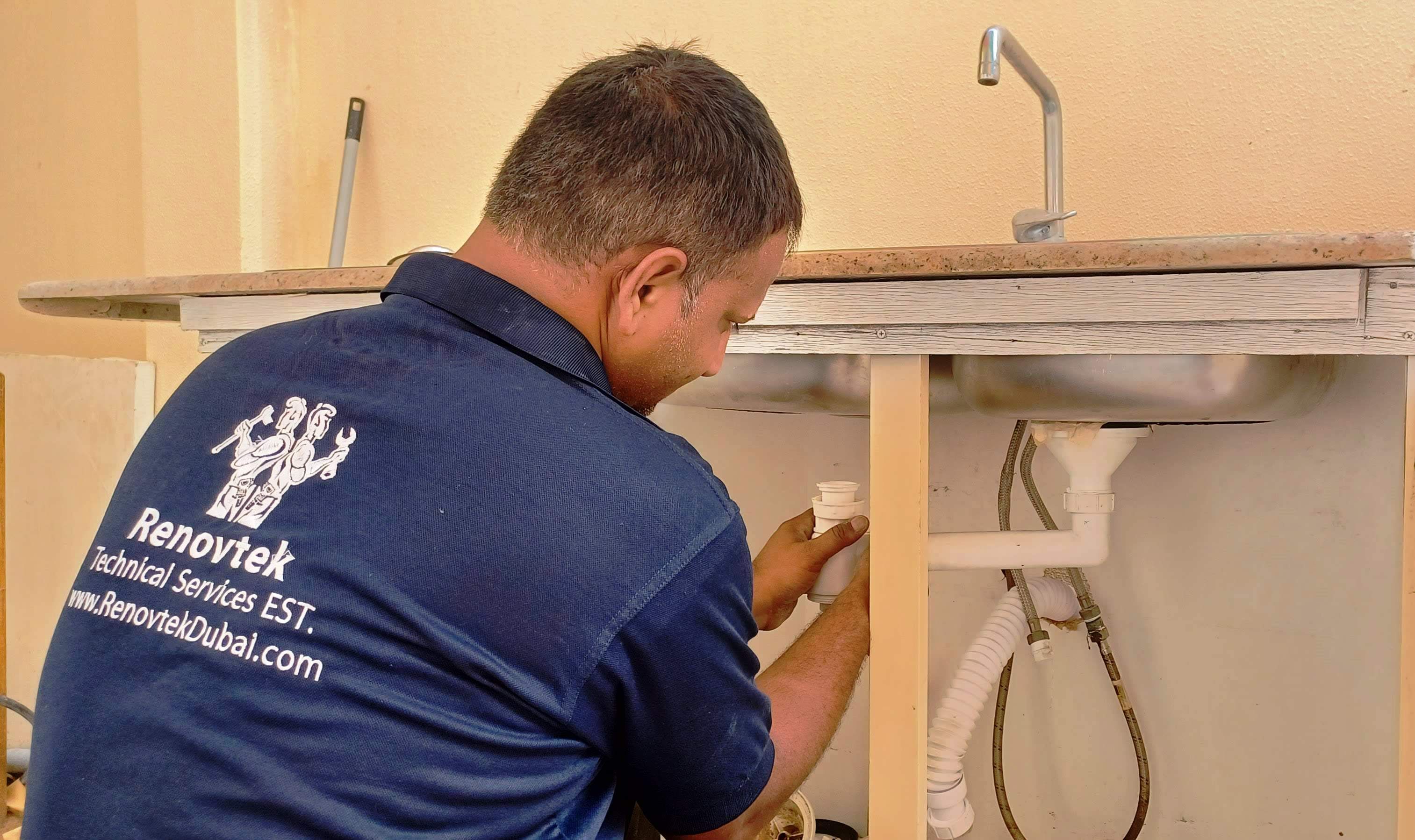 technician fixing new pipe for a sink in Dubai