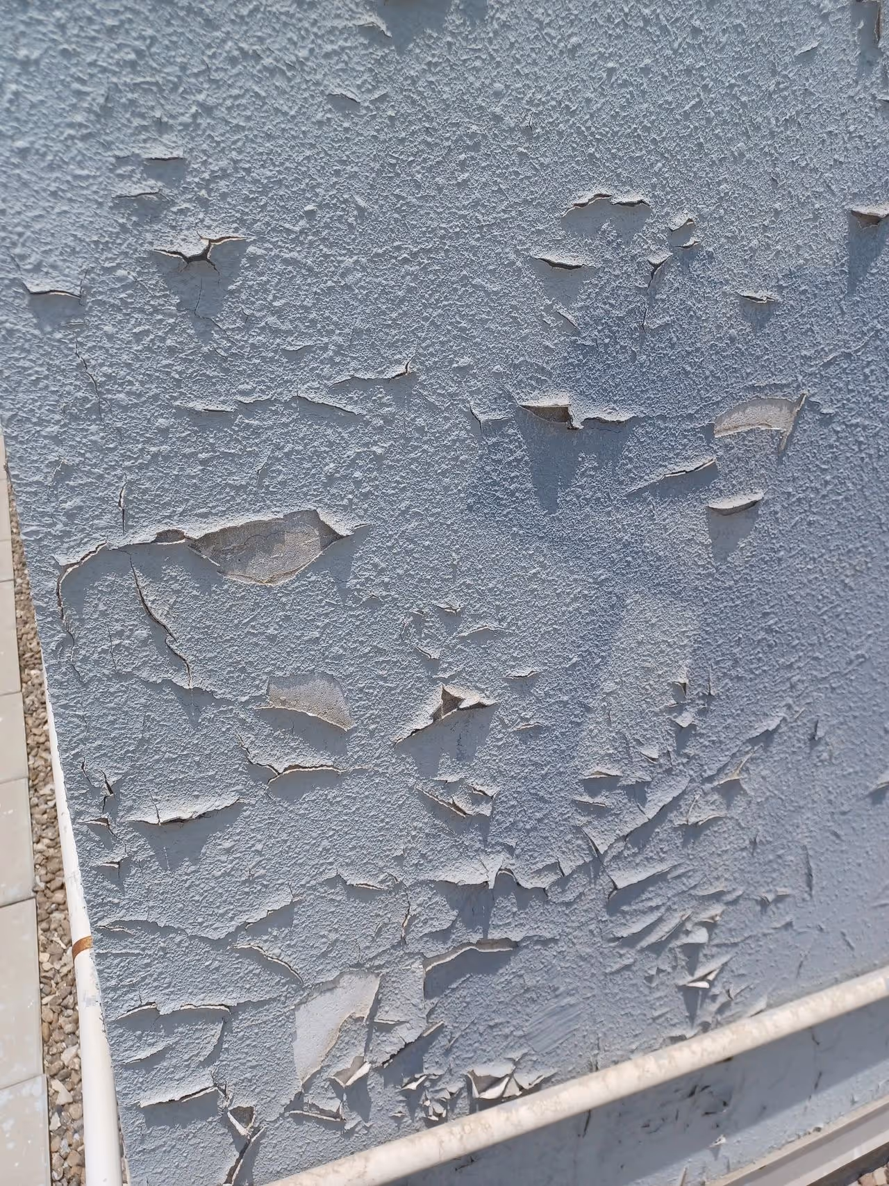 Damaged paint on external wall before restoration